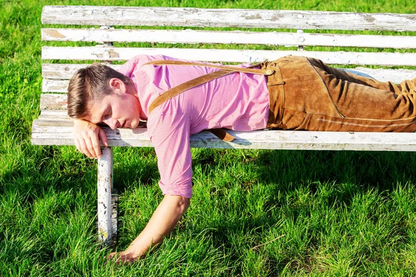 Loiro bávaro homem dormindo ao ar livre em um banco — Fotografia de Stock