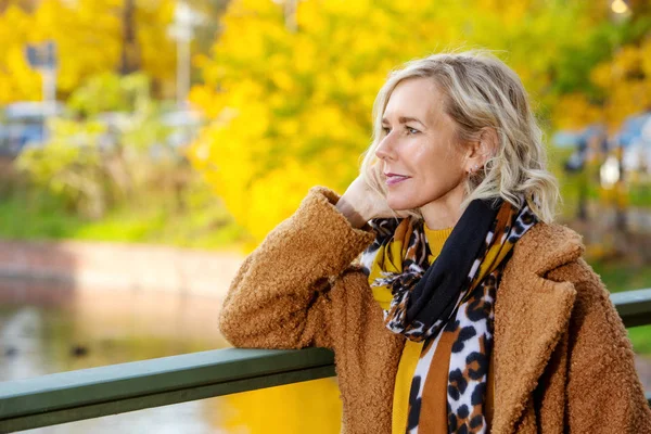 Mujer rubia en sus 40 años al aire libre disfrutando del sol de otoño —  Fotos de Stock