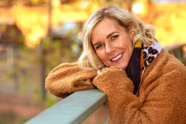 Blond kvinna i 40-årsåldern utomhus njuter av höstsolen — Stockfoto