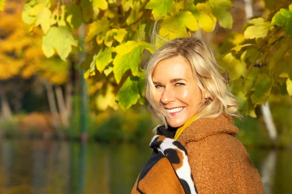 Femme blonde dans la quarantaine à l'extérieur profitant du soleil d'automne — Photo