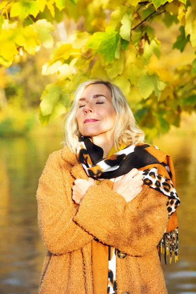 Blond kvinna i 40-årsåldern utomhus njuter av höstsolen — Stockfoto