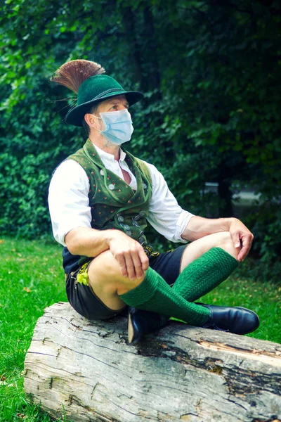 Bavarian Man Sitting Tree Stump Wearing Protective Mask — Stock Photo, Image