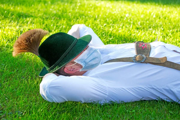 草の上に寝そべって保護マスクをして — ストック写真