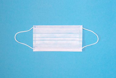 Mavi arkaplanda bir yüz maskesinin yakın çekimi