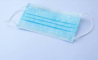 Beyaz arkaplanda mavi bir yüz maskesi yakın plan