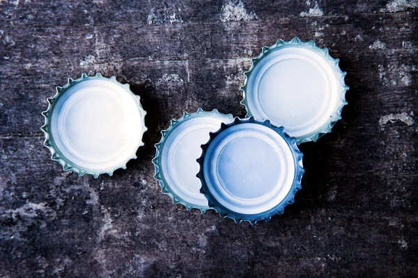 Four Bottle Caps Rustic Wooden Table — Stock Photo, Image