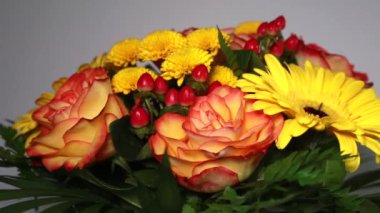 Renkli buketin yakın plan görüntüsü. Dönen tabakta turuncu bir gül var.