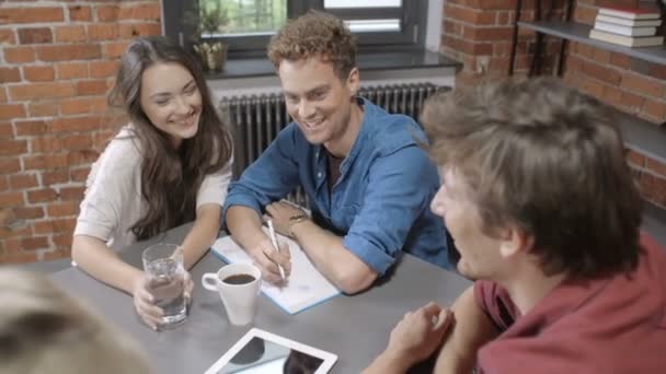 Grupo de jóvenes alegres discutiendo proyecto . — Vídeo de stock