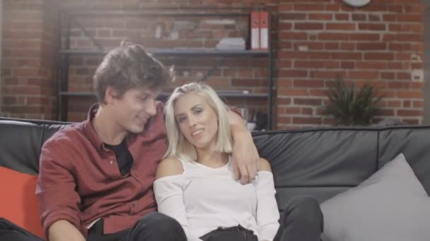Ritratto di giovane coppia sorridente a casa moderna. Coppia attraente relax in divano, indoor . — Video Stock