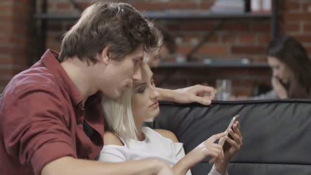 Hermosa pareja joven hipster utilizando el teléfono en casa . — Vídeo de stock