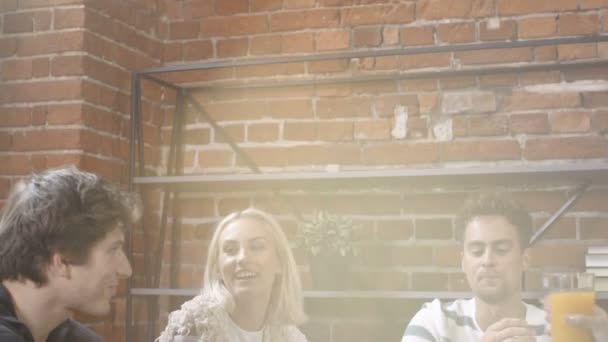 Grupp unga vänner pratar runt ett bord med orange hälsodrycker i en fritid dag i moderna loft interiör. — Stockvideo