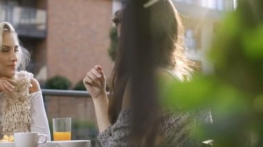 Güzel söz, içme ve masada oturan ve açık havada piknik güneşli havanın tadını gençler.