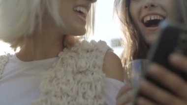 Seyir akıllı telefon ve eğleniyor, açık iki mutlu genç kız. 