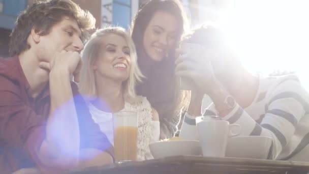 Група друзів, які користуються телефоном протягом сонячного дня . — стокове відео