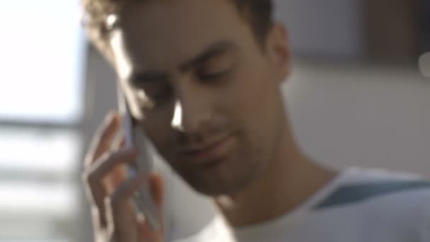 Вид профілю красивого молодого чоловіка, який розмовляє по телефону в місті . — стокове відео