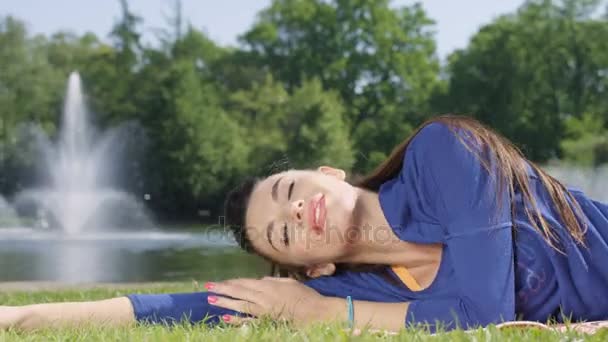 Young beautiful woman resting and relaxing after fitness exercise. — Stock Video