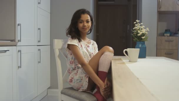 Mulher feliz sorrindo para a câmera enquanto sentado em casa na cozinha . — Vídeo de Stock