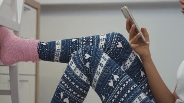 Young woman sitting in a kitchen floor and talking on mobile phone. — Stock Video