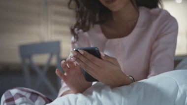 Evde cep telefonu kullanan mutlu genç bir kadın..