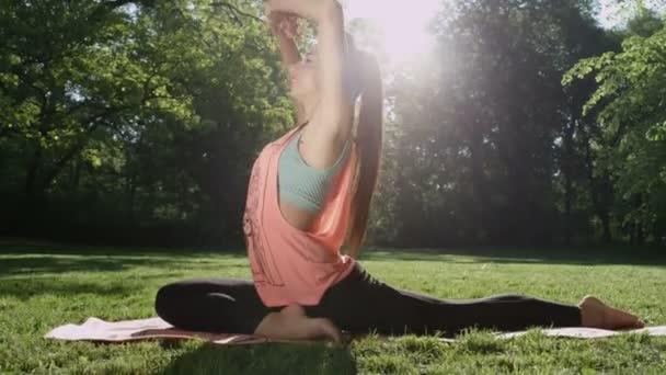 Young woman stretching in  sunny park. — Stock Video