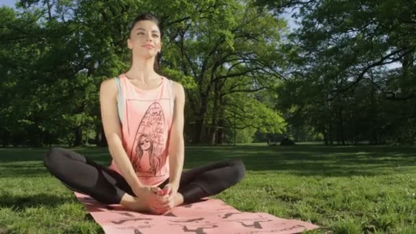 Jeune femme s'étirant dans un parc ensoleillé .