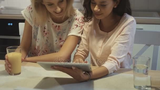 Δύο όμορφα κορίτσια χρήση tablet στο σπίτι. — Αρχείο Βίντεο