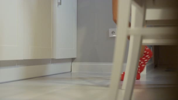 Kvinnliga ben med röda strumpor promenader i köket. — Stockvideo