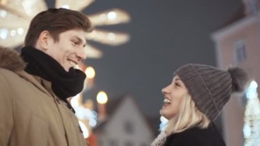 Bir şehirde akşam ışıklar üzerinde vaktinizi aşık genç mutlu çift.