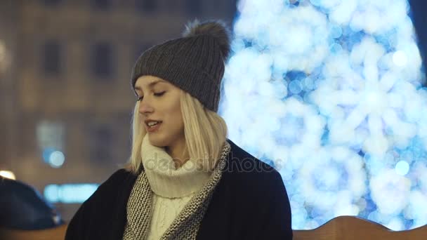 Fiatal lány várja barátja, a karácsonyi vásár. — Stock videók