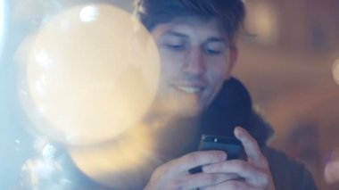 Geceleri onun cep telefonu kullanan genç adam portresi.