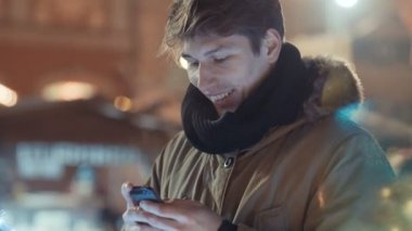 Geceleri onun cep telefonu kullanan genç adam portresi.