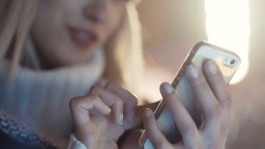 Cep telefonuyla bir şehirde gece genç kadın.