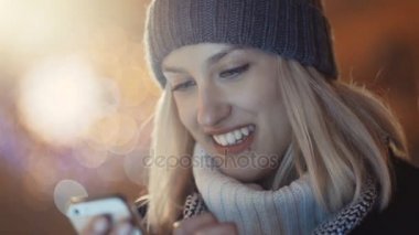 Cep telefonuyla bir şehirde gece genç kadın.