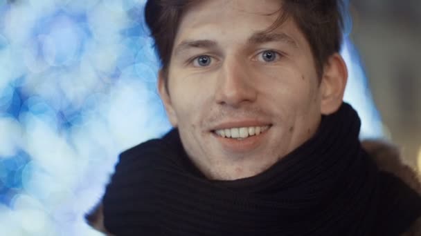 Joven hombre guapo sonriendo sobre fondo bokeh . — Vídeos de Stock