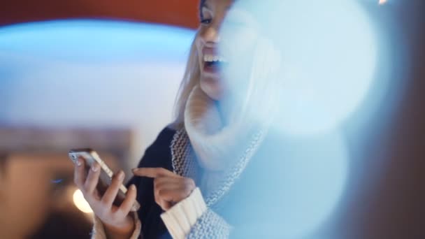 Jeune femme utilisant un téléphone portable dans une ville la nuit . — Video