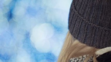 Genç sarışın kız kameraya bakarak ve gülümseyen Noel pazarında.