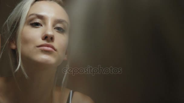 Mujer joven mirando su cara en el espejo del baño en casa . — Vídeos de Stock