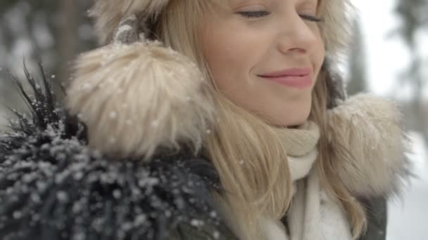 Портрет улыбающейся женщины, наслаждающейся зимой в лесу . — стоковое видео