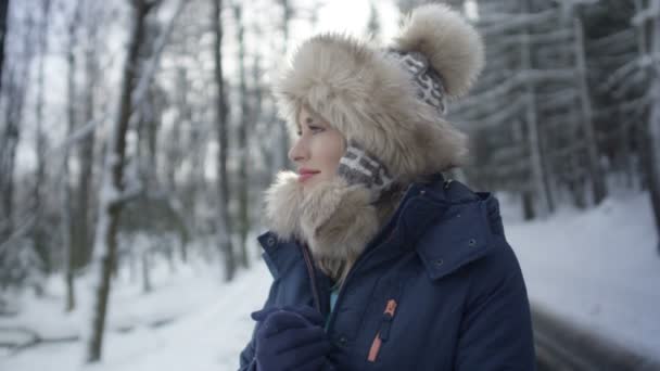 산 숲에서 겨울을 즐기고 웃는 여자의 초상화. — 비디오