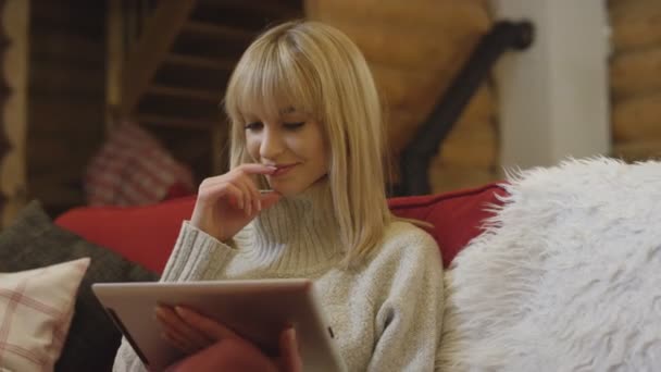 집에서 하는 태블릿을 사용 하 여 겨울에 스웨터를 입고 아름 다운 소녀. — 비디오