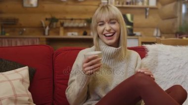 Genç kadın evde koltukta oturan gülmeyi kes olamaz.