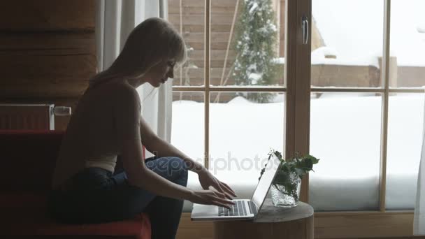 Giovane donna che utilizza un computer portatile a casa . — Video Stock