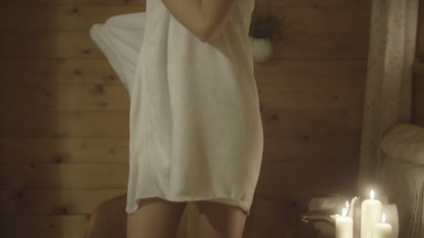 Mladá žena po přijetí koupele v dřevěné vaně.