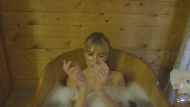 Mujer joven tomando baño en una bañera de madera . — Vídeo de stock