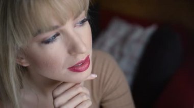 Düşünceli kadın kolları olan bir pencereden bakarak geçti.