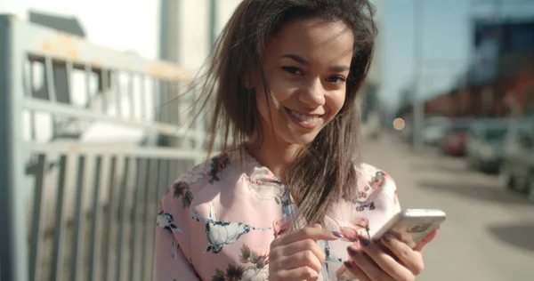 Retrato de una joven afroamericana usando teléfono, al aire libre . — Foto de Stock