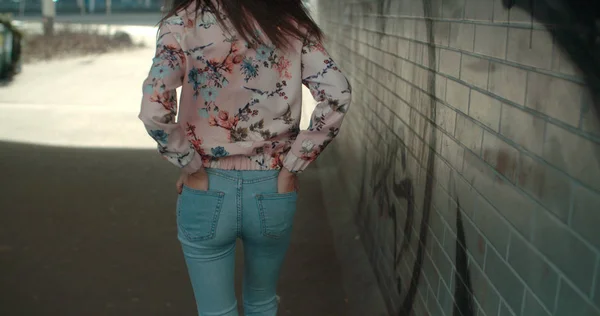 Vista trasera de una joven caminando por las calles de una ciudad . — Foto de Stock