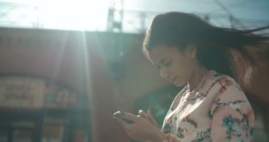Telefon, açık havada kullanan genç Afro-Amerikan kadın portresi.