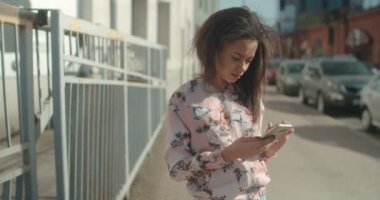 Telefon, açık havada kullanan genç Afro-Amerikan kadın portresi.