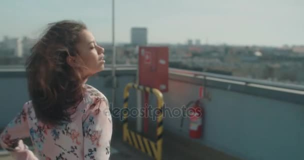 Mooie jongedame genieten van tijd op een parking op het dak. — Stockvideo